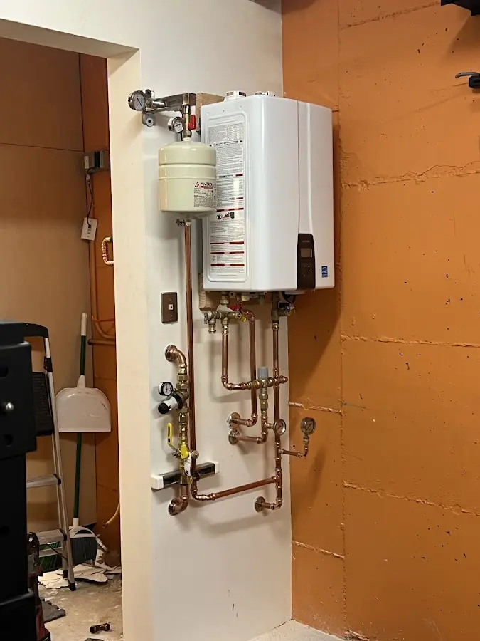 Plumbing technician inspecting water heater connections in North Auburn